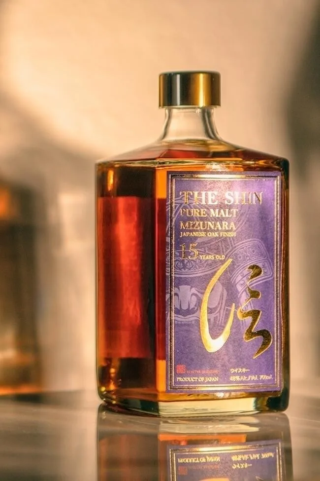 a bottle of the Shin pure malt 15 year old whisky with a shadow in the background